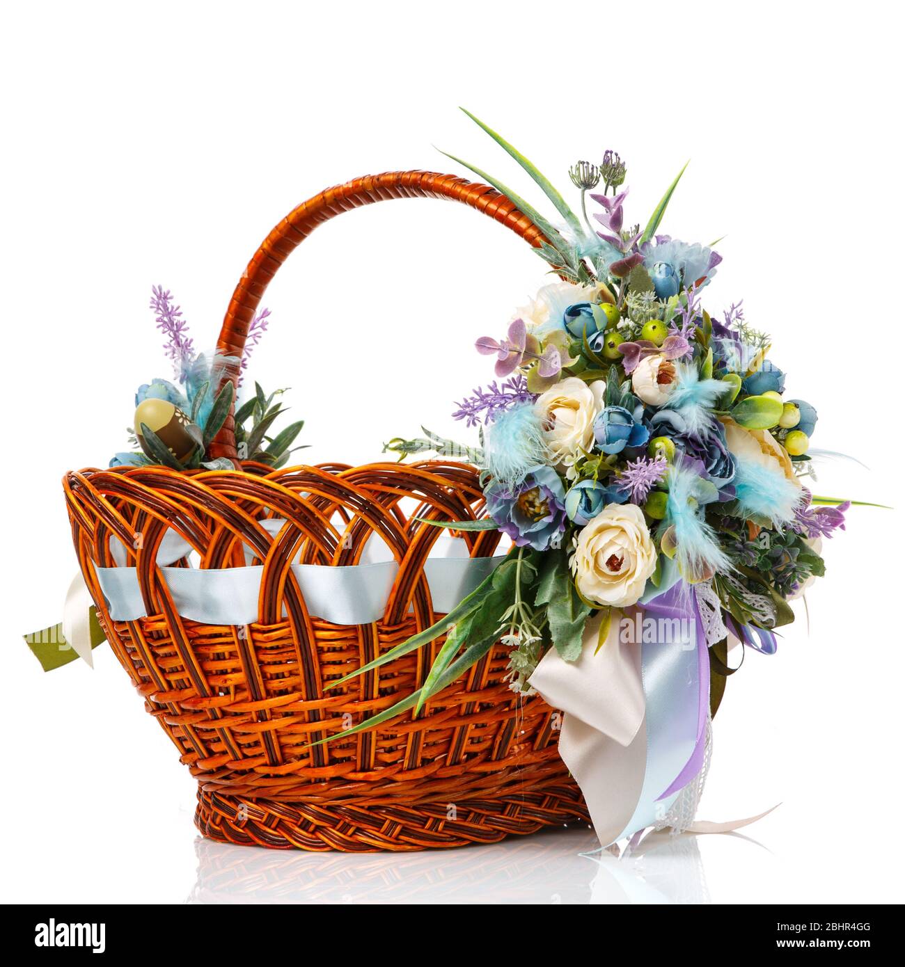 Magnifique panier décoratif avec fleurs pour la fête de Pâques sur fond blanc Banque D'Images