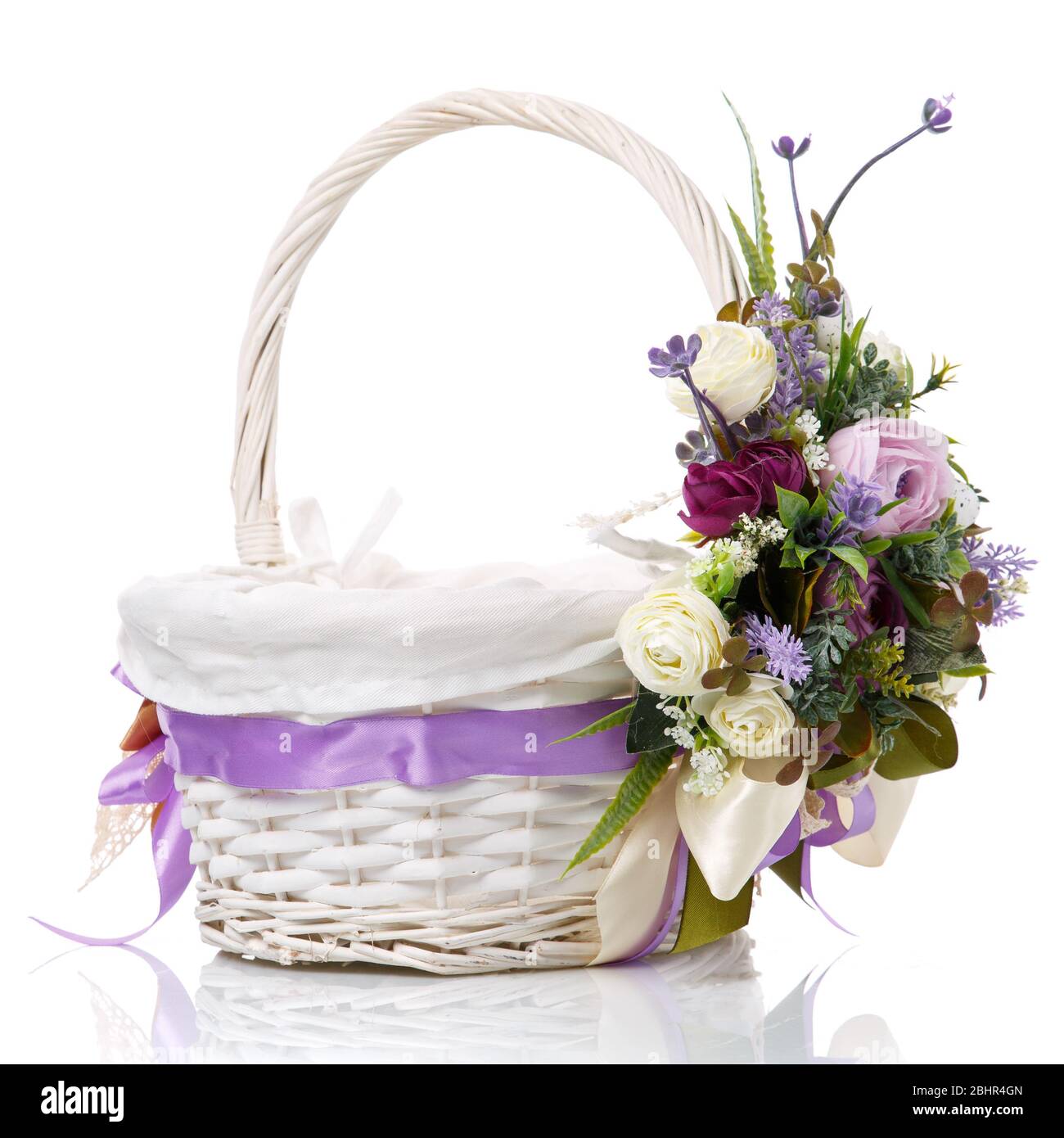 Magnifique panier décoratif avec fleurs pour la fête de Pâques sur fond blanc Banque D'Images
