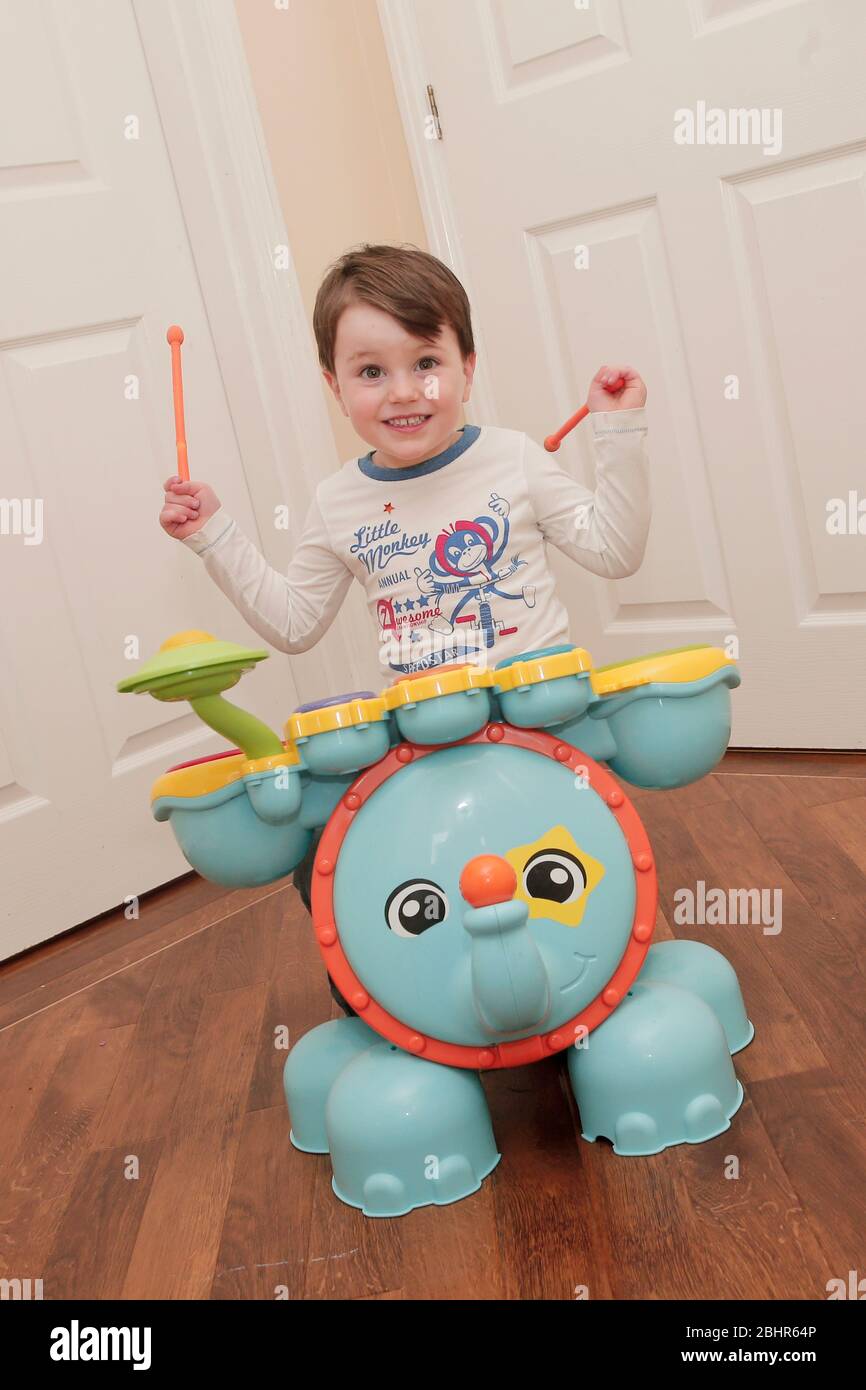 Un garçon de deux ans jouant à la batterie à la maison Banque D'Images