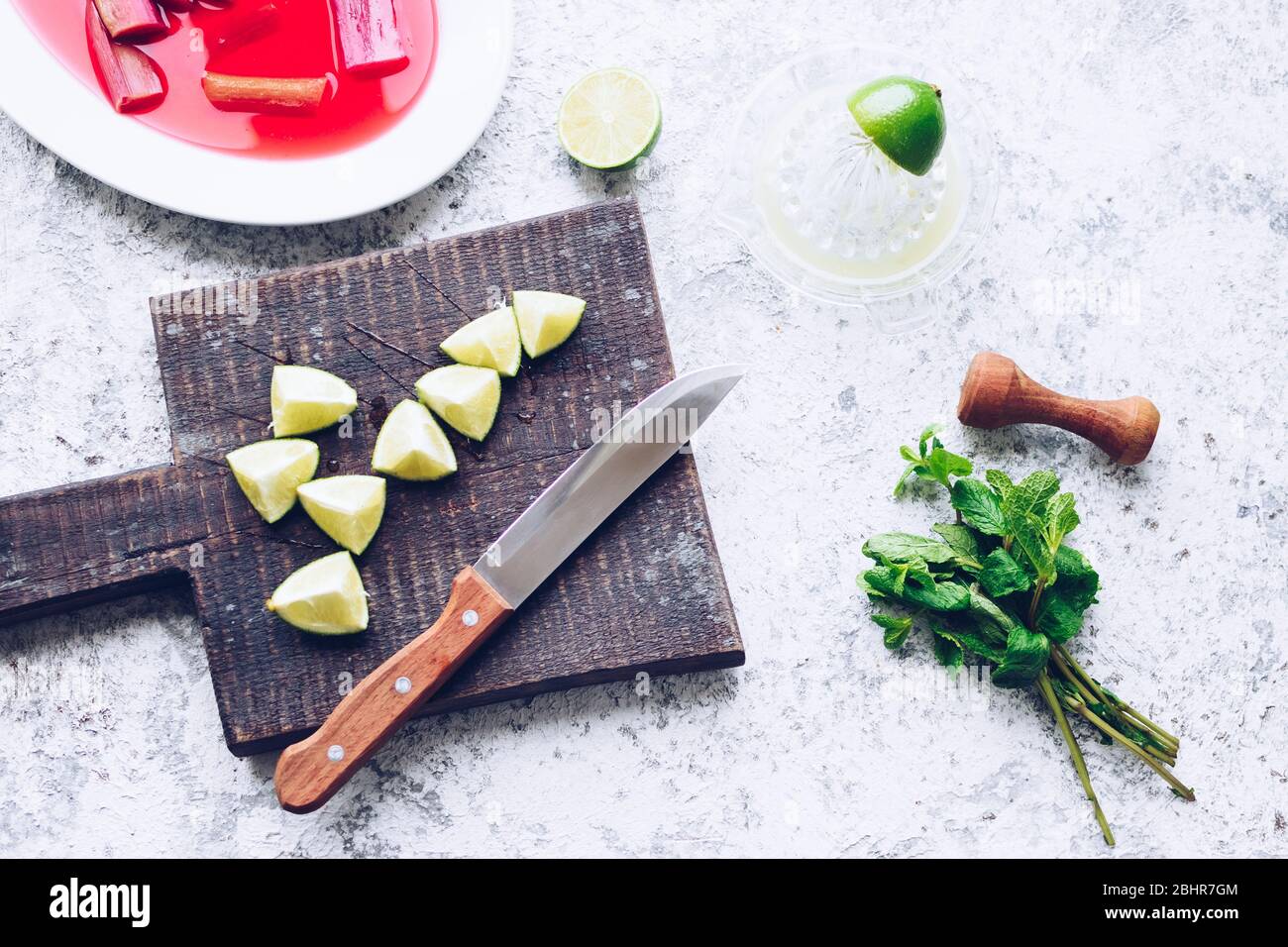Processus de fabrication de cocktails mojito avec rhubarbe pochée. Boisson rafraîchissante d'été avec rhubarbe, citron vert et menthe. Limonade de rhubarbe. Vue de dessus. Banque D'Images