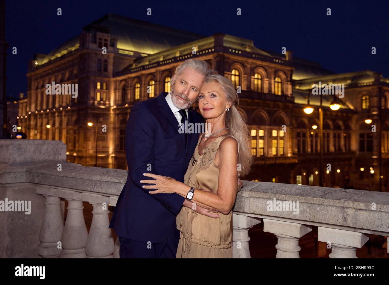 Un bras de couple plus âgé au bras par une balustrade pendant une soirée à Vienne. Banque D'Images