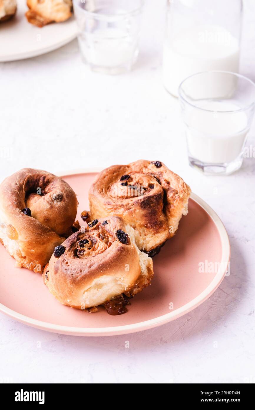 Petits pains à la cannelle servis en assiette sur la table du matin du petit déjeuner, gros plan Banque D'Images