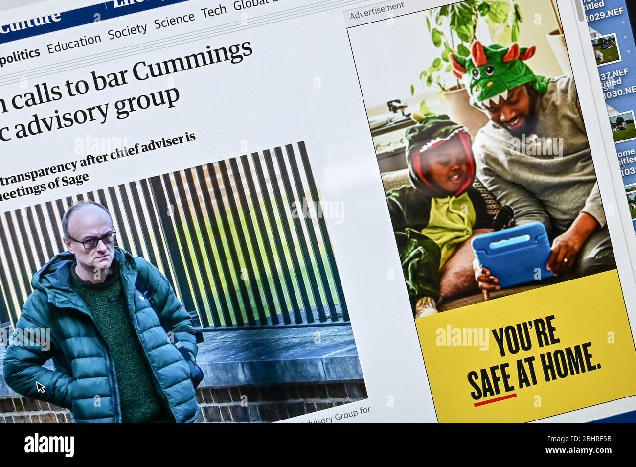 Informations publiques en ligne Coronavirus/ Covid annonce, 'vous êtes sûr à la maison' juxtaposée à un article et une photo présentant Dominic Cummings. Banque D'Images