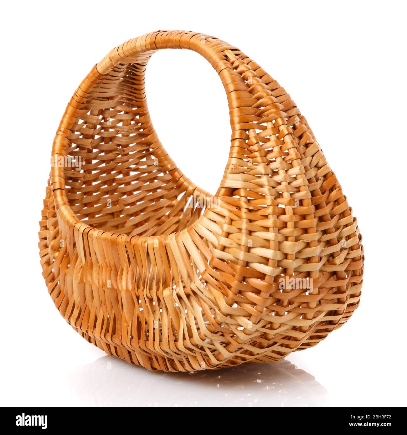 Le panier en osier brun original est de forme ovale fait de vignes sur fond blanc. Banque D'Images