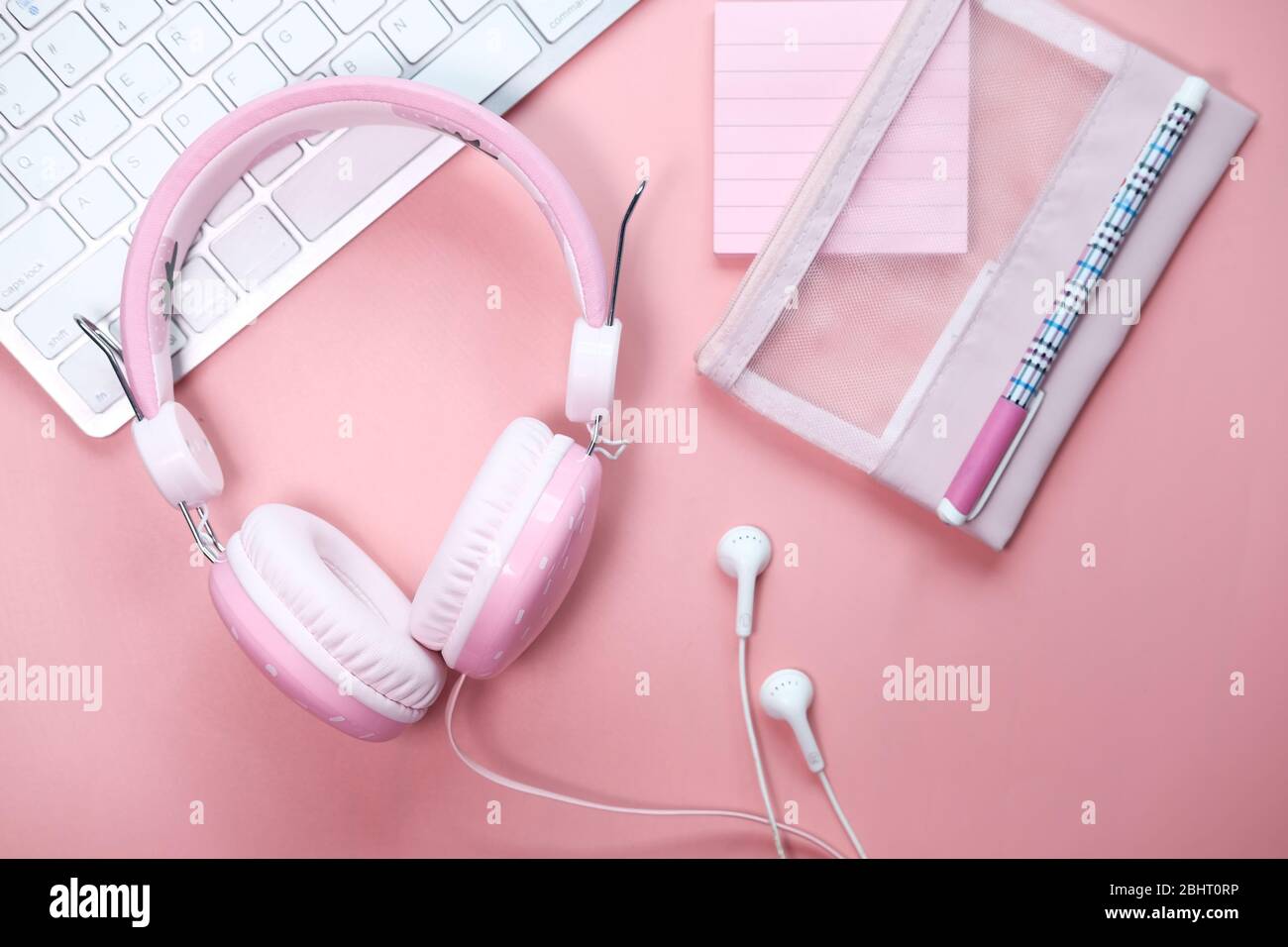 casque couleur rose sur un clavier sur fond rose Banque D'Images
