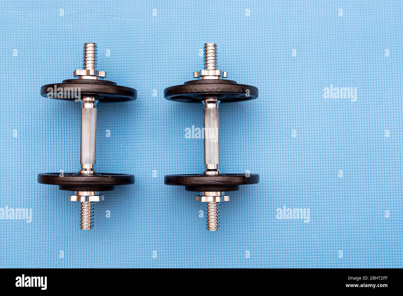 Deux haltères en fer sur le tapis bleu, concept sport Picture Banque D'Images