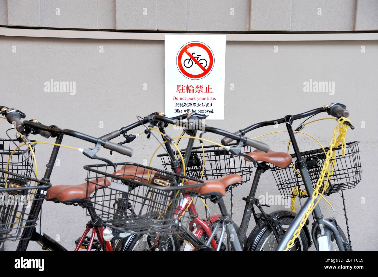 Multilingue pas de vélos parking se connecter Kyoto, Japon avec des vélos garés devant. Accent sélectif sur le signe. Banque D'Images