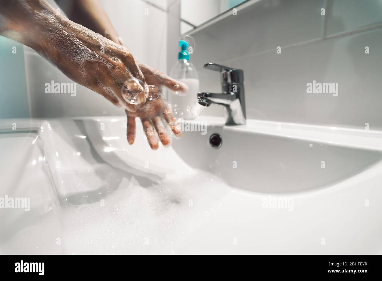 Les femmes se lavent les mains avec du savon liquide pour prévenir et arrêter la propagation du virus corona - concept d'hygiène et de santé Banque D'Images