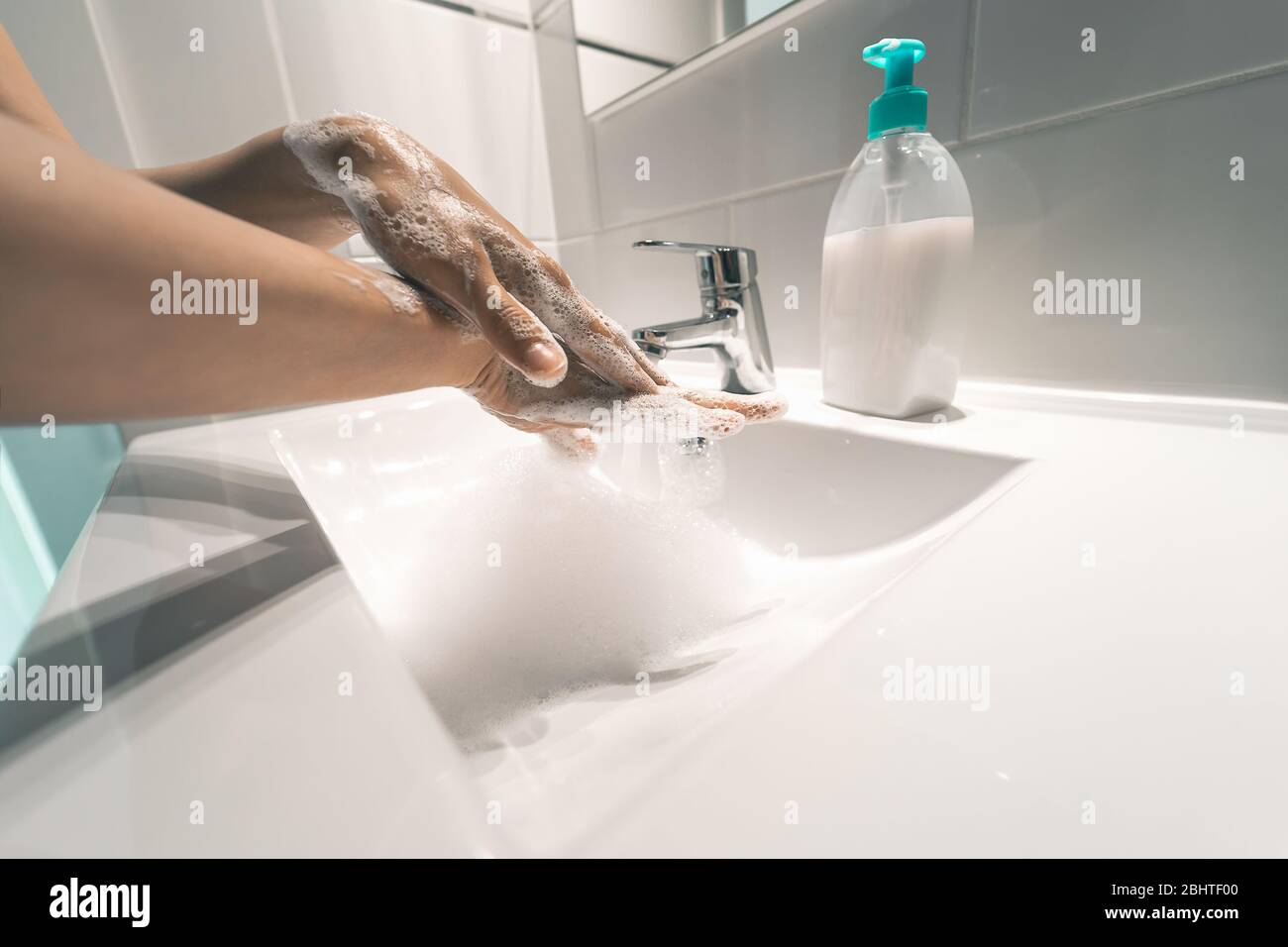 Les femmes se lavent les mains avec du savon liquide pour prévenir et arrêter la propagation du virus corona - concept d'hygiène et de santé Banque D'Images