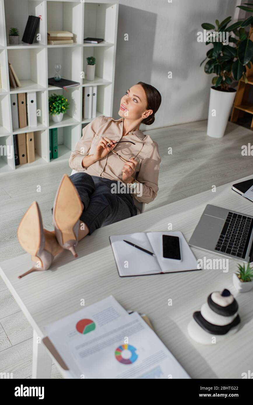 belle jeune femme d'affaires procrasting avec des pieds sur table au bureau Banque D'Images