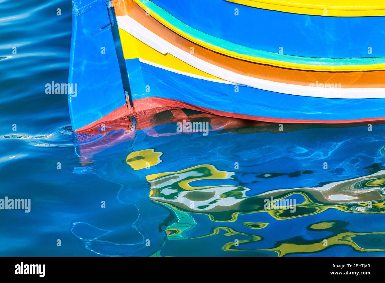 Réflexions de la poupe de luzzo bateau de pêche traditionnel, Marsaxlokk, Malte Banque D'Images