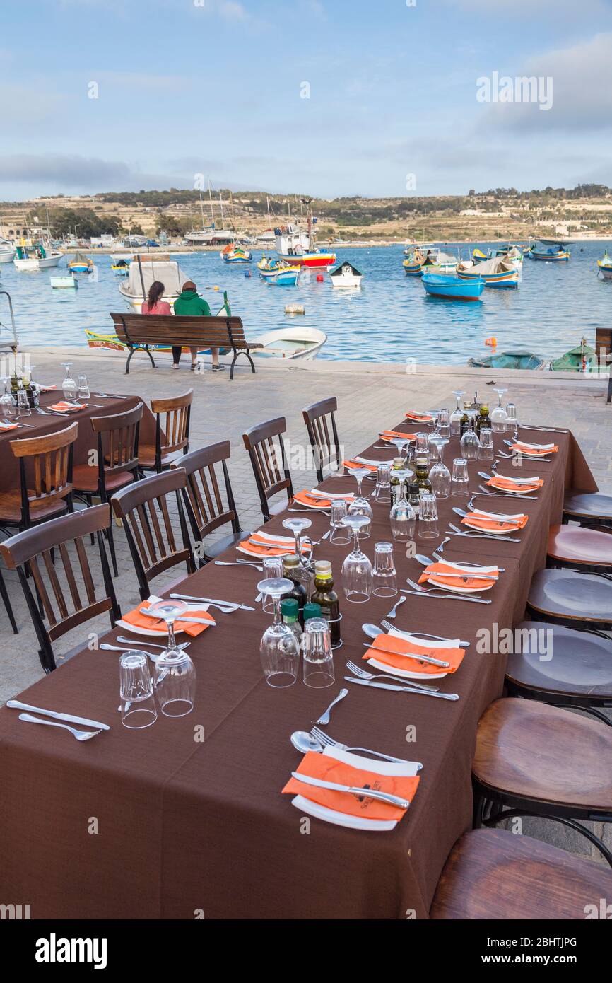 Table à manger avec des endroits situés à l'extérieur sur quai, Marsaxlokk, Malte Banque D'Images