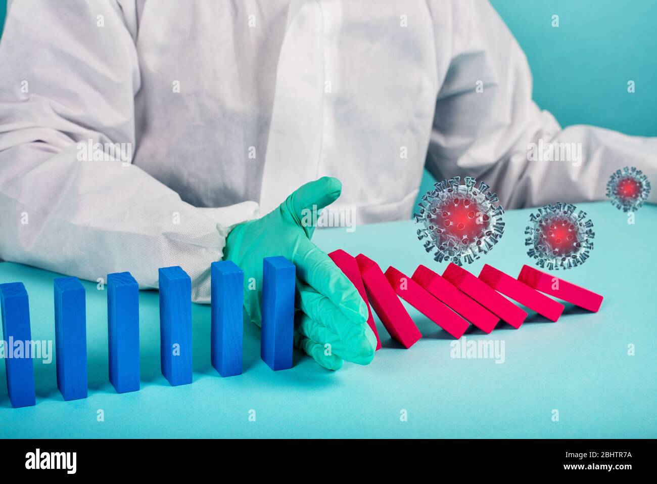 Concept de pandémie de coronavirus covid19 avec chaîne en chute libre comme un jeu domino. Contagion et progression de l'infection stoppées par une main d'un médecin. Cyan Banque D'Images