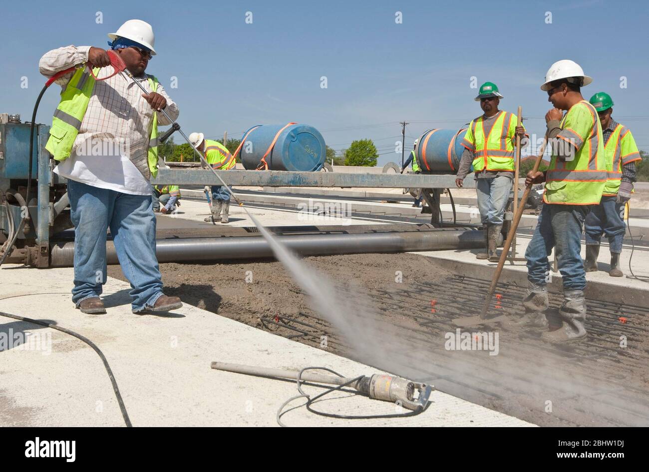 Austin Texas Etats-Unis, 6 avril 2011: Le travailleur pulvérise de l'eau pour assurer la bonne température du béton fraîchement coulé le long de la route en construction. ©Marjorie Kamys Cotera/Daemmrich photos Banque D'Images