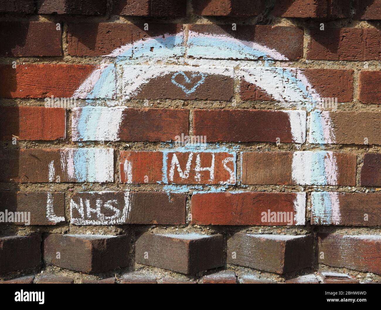 Vue d'un arc-en-ciel craqué sur un mur de briques par les enfants pour montrer le soutien aux travailleurs de soins et au NHS pendant la pandémie de coronavirus de 2020 Banque D'Images