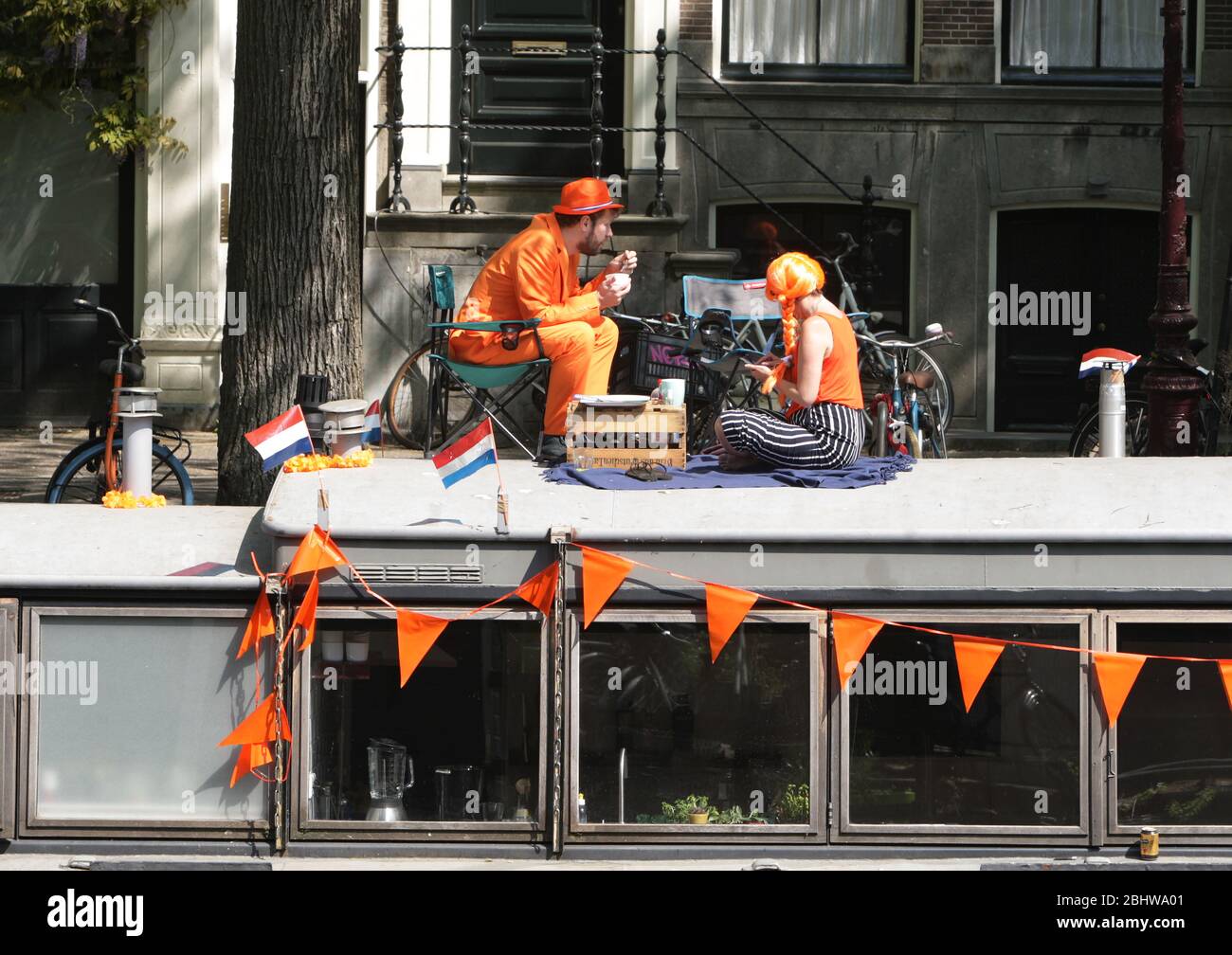 Un couple sur la maison de bateau se célèbre pendant la Journée du roi au milieu de la pandémie de Coronavirus le 27 avril 2020 à Amsterdam, aux Pays-Bas. L'anniversaire du roi Banque D'Images