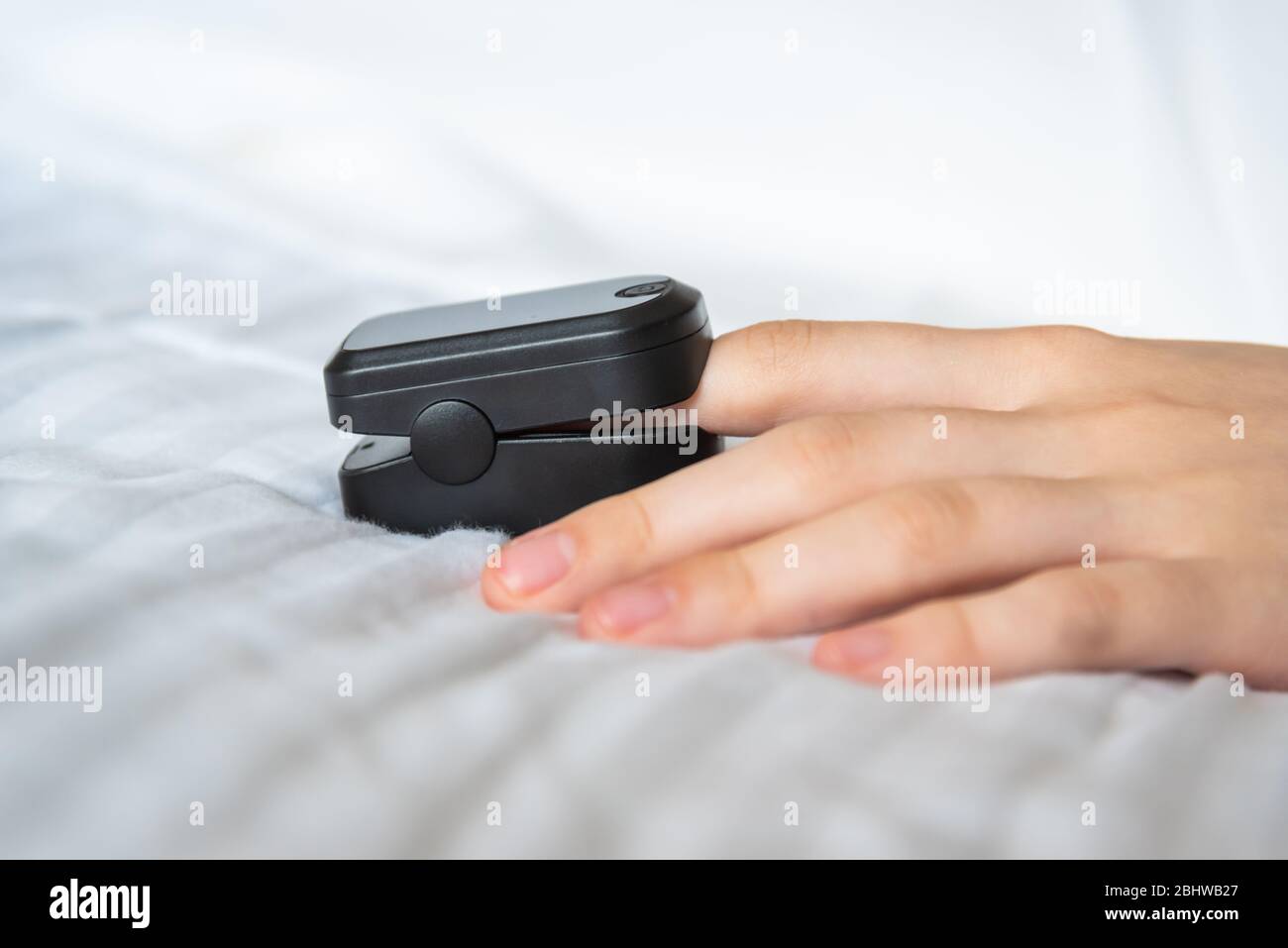 Gros plan de l'oxymètre de pouls sur le doigt de la femme avec une feuille blanche et un espace de copie Banque D'Images