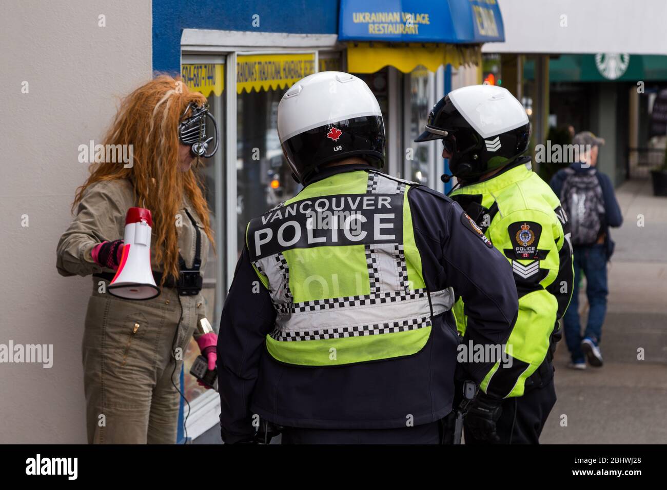 CENTRE-VILLE DE VANCOUVER, C.-B., CANADA - 26 avril 2020 : un membre d'Antifa est détenu par la police lors d'une manifestation anti-verrouillage. Banque D'Images