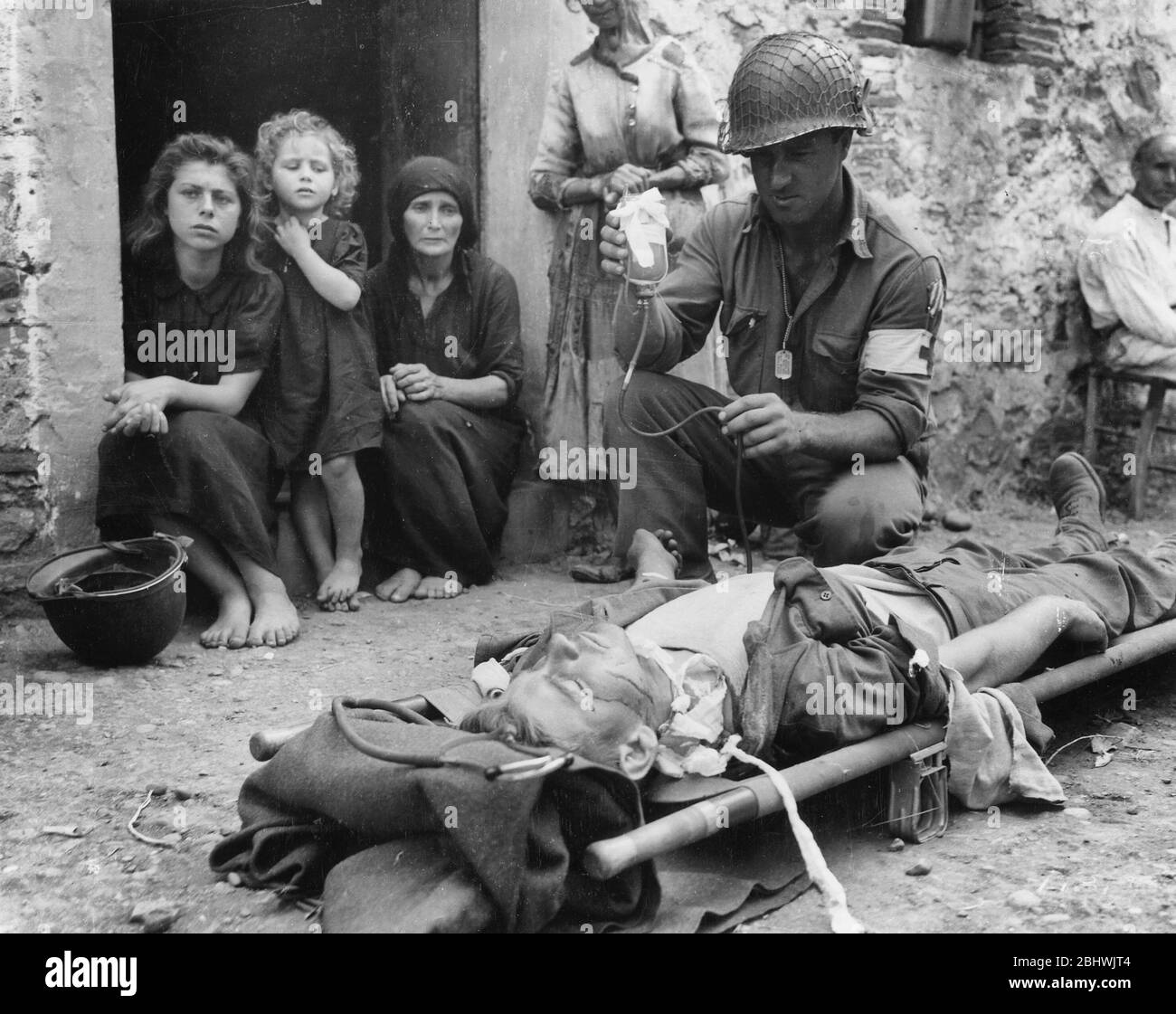 Un soldat reçoit du plasma sanguin après qu'il a été blessé par un shrapnel en Sicile le 9 août 1943 Banque D'Images