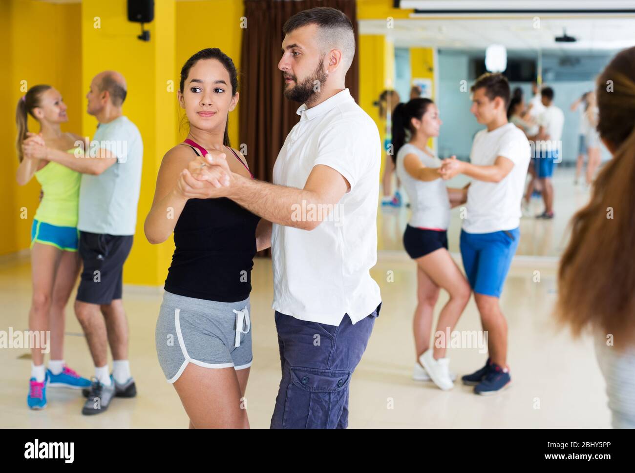Des adultes positifs dansant la salsa ensemble dans la salle de danse Banque D'Images