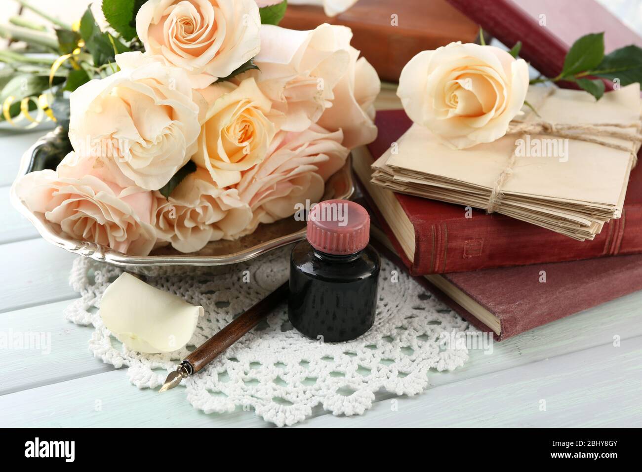 Roses fraîches avec vieux livre et lettres sur fond de table en bois couleur. Concept vintage Banque D'Images