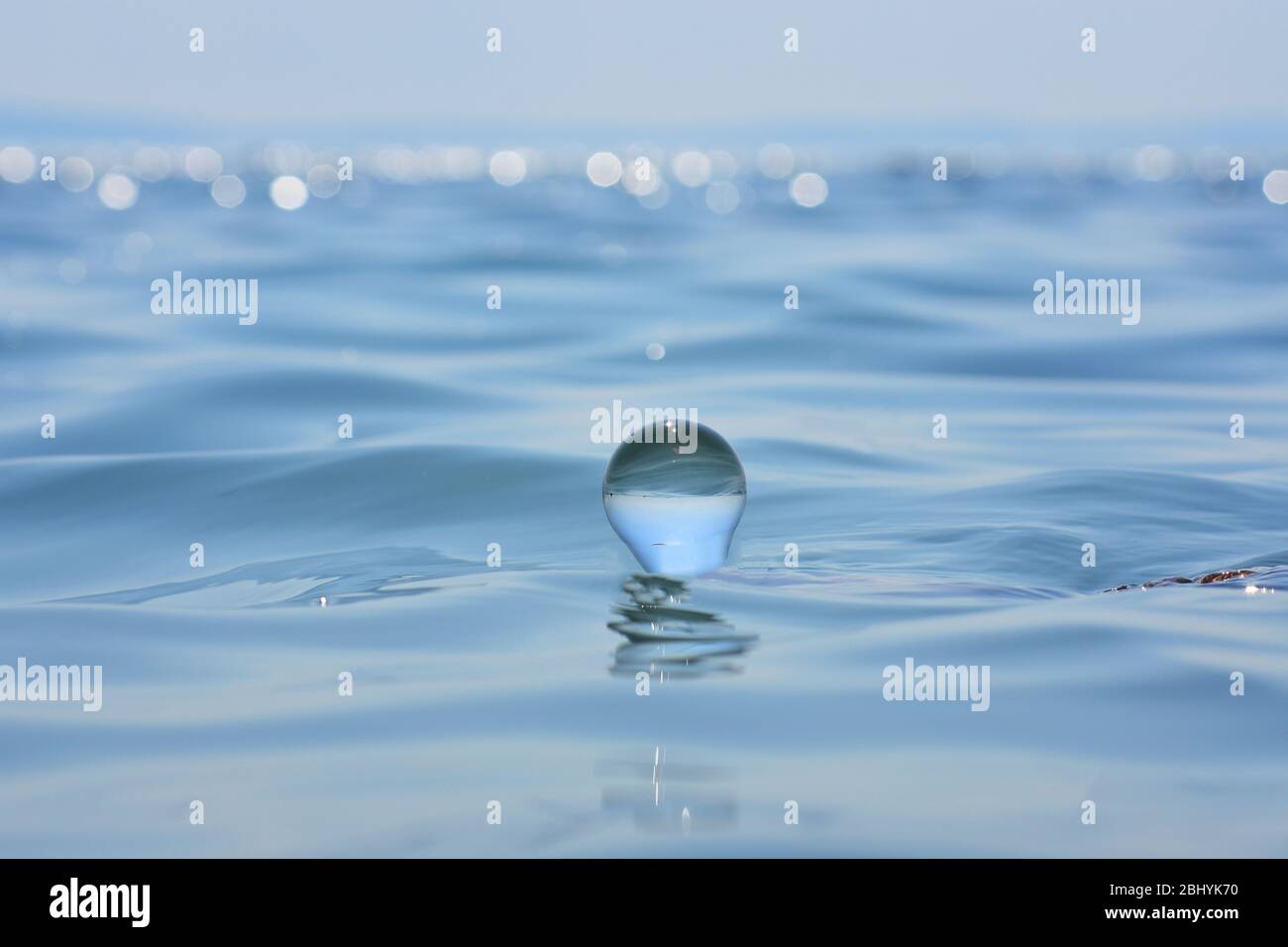 Belle Côte d'été vu à travers une boule de verre bleu/bleu liberté concept/ Surface de l'océan vagues et nuages dans le ciel capturés en Bille de verre Banque D'Images