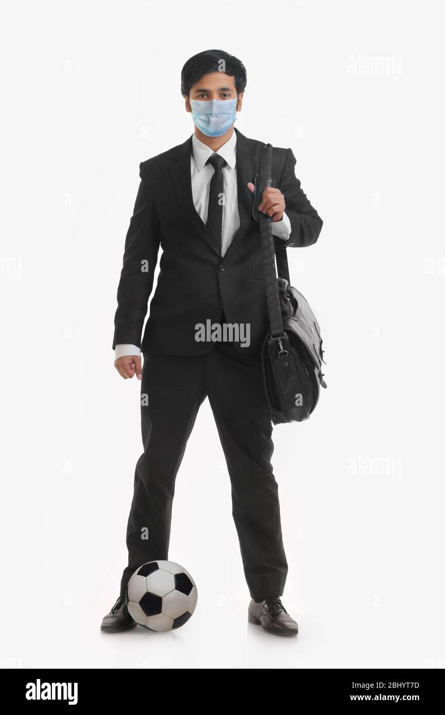 Portrait of businessman carrying sac à main et de football entre les deux pieds. Banque D'Images