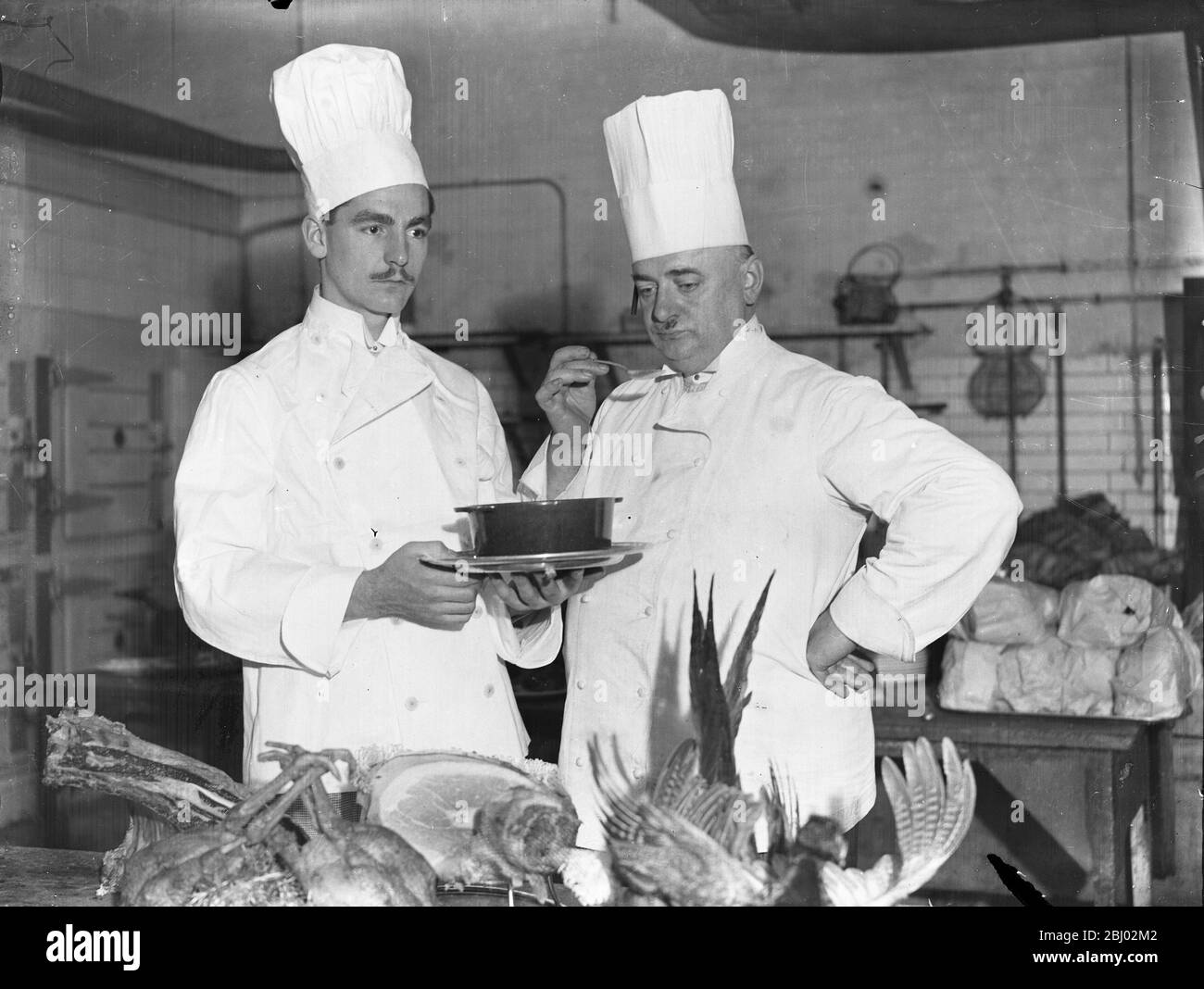 Le fils de l'amiral comme chef - M. Roderick Stanhope Wemyss , fils du vice-amiral Edward Wemyss , travaille maintenant à Grosvenor House comme chef adjoint . La première étape de sa nouvelle carrière de gérer un hôtel . - M . H Malet , le chef , dans une photo est vu à droite , dégustation de soupe préparée par M. Wemyss - 13 janvier 1933 Banque D'Images