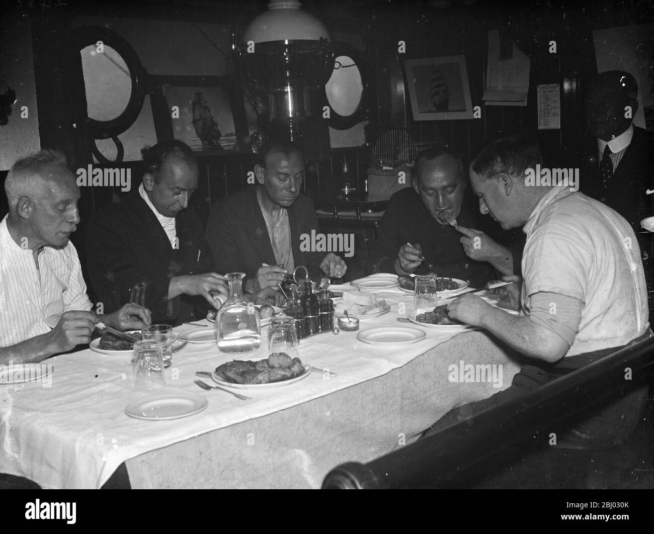 Certains membres de l'équipage du tramp cuiseur vapeur , le ' SS Eston ' manger le dîner dans le navire ' s mess . - 1935 Banque D'Images