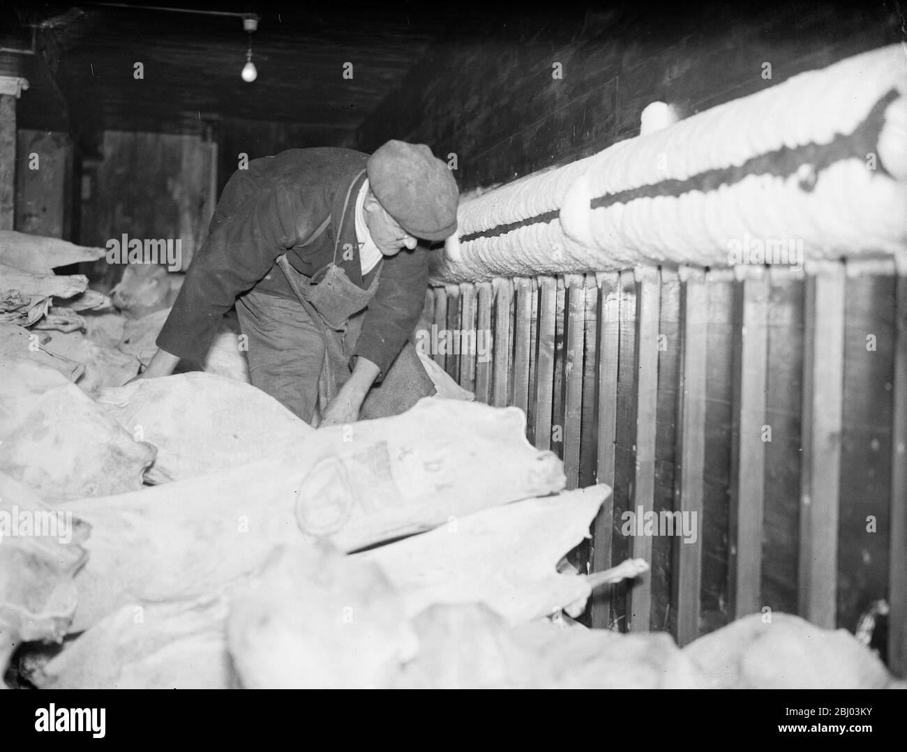 Londoner qui porte toujours des chapeaux et des manteaux ! . Ils fonctionnent dans le stockage à froid . - même dans ce brûlant août il y a un endroit à Londres où les chapeaux et les manteaux sont toujours les bienvenus . - c'est le froid stockage de l'Administration du Port de Londres dans Charterhouse Street , où les hommes manipulent la viande toute la journée avec des vêtements lourds comme protection contre la frsot . - 8 août 1935 Banque D'Images