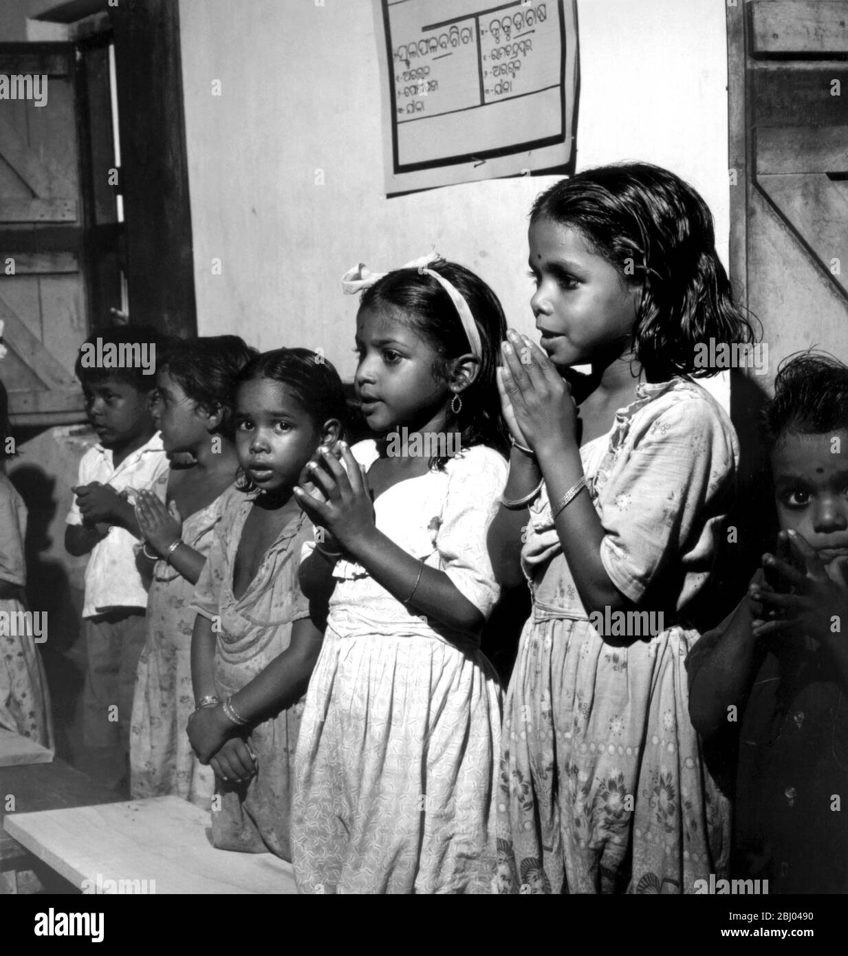 Les élèves disent leurs prières hindous avant le déjeuner de mi-journée fourni par l'école. Par le biais du déjeuner scolaire, le Programme élargi de nutrition a introduit de meilleures habitudes alimentaires pour les jeunes et éduque l'entrée de la nutrition. Banque D'Images
