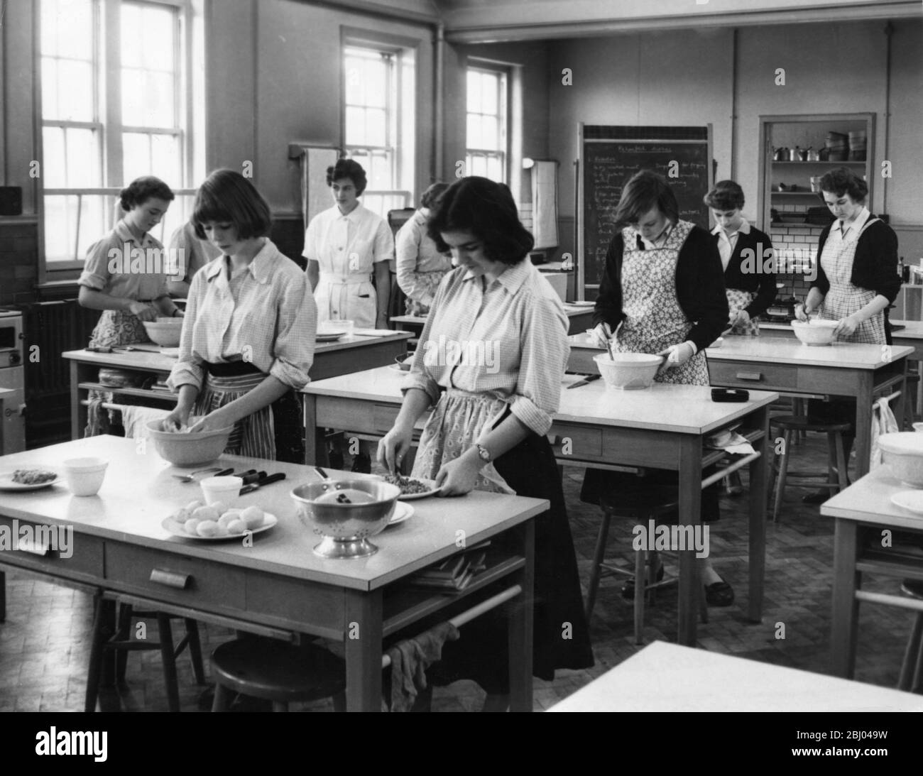 Les écolières apprennent la cuisine lors d'un cours de sciences intérieures à l'école Queen Elizabeth Grammar pour filles, qui doit être visité par la Reine. 1957 Banque D'Images