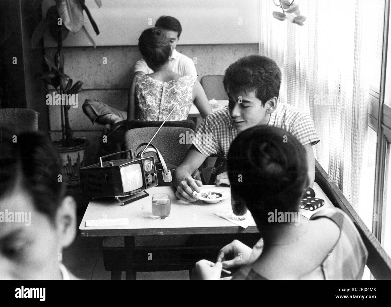 Les jeunes dans un café regardant une petite télévision portable - - - - - - Banque D'Images