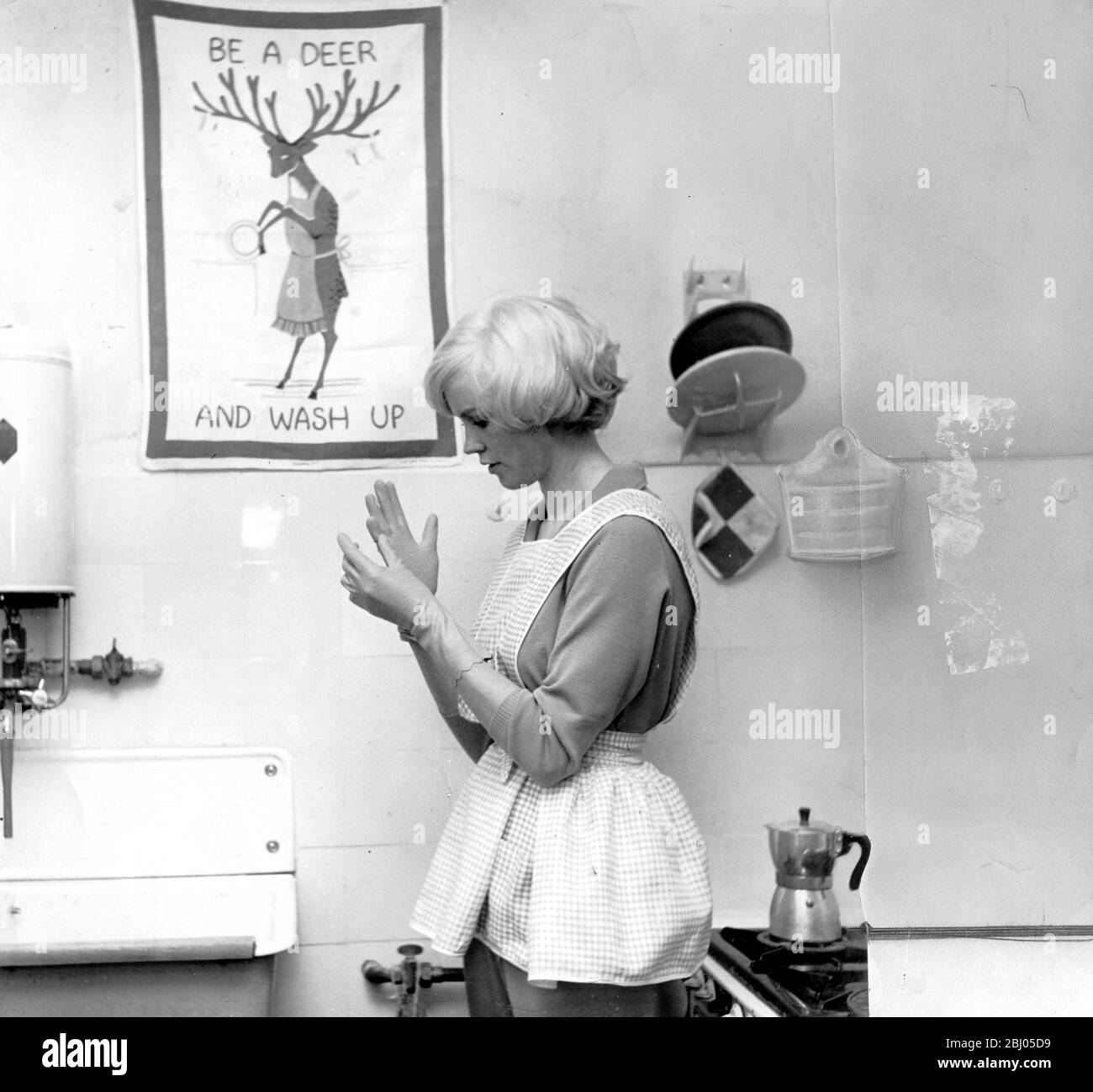 Prenez soin de vos ongles portez des vêtements en caoutchouc lorsque vous faites des tâches ménagères 1960 Banque D'Images