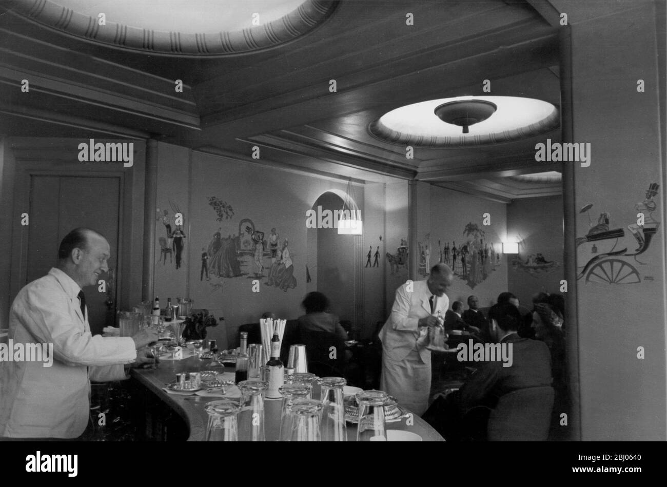 The Ritz Hotel, Piccadilly, Londres. - dans l'un des grands hôtels de Londres, le bar à cocktails Rivoli face à Piccadilly a été ouvert pendant la guerre. L'un des premiers appels d'offres au bar était le célèbre Harry du New York Bar Paris de Harry, qui avait été dépossédé par l'occupation allemande. Dans les années 50, lorsque cette photo a été prise, les cocktails ont varié de 3/6 à 8/- pour un cocktail au champagne. - Banque D'Images
