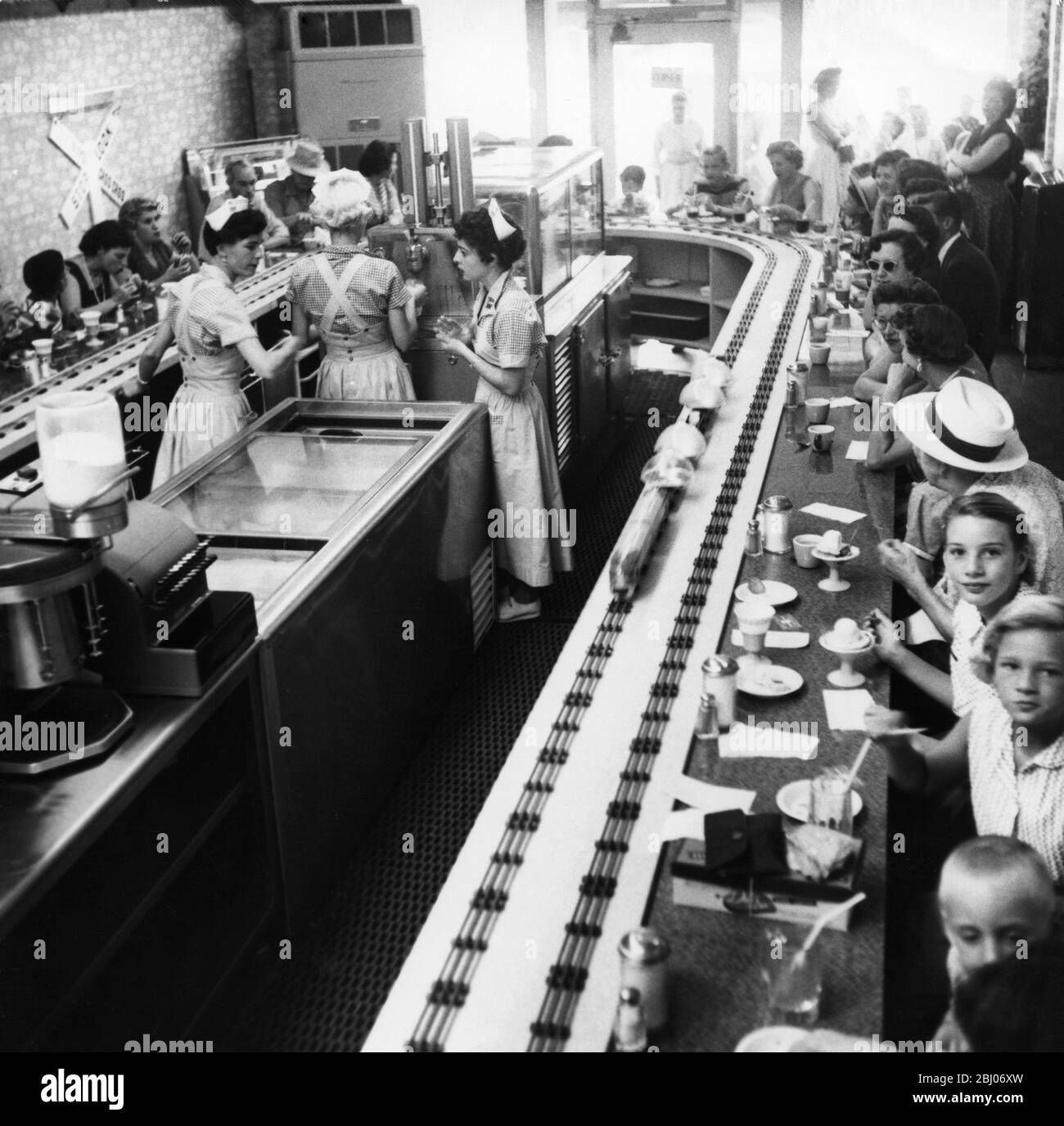 Dîner américain avec nourriture livrée par des trains modèles. Les jeunes sont tellement intrigués par les trains qu'il est difficile de les laisser après qu'ils ont fini de manger. - Van Nuys Choo Choo - Californie Banque D'Images