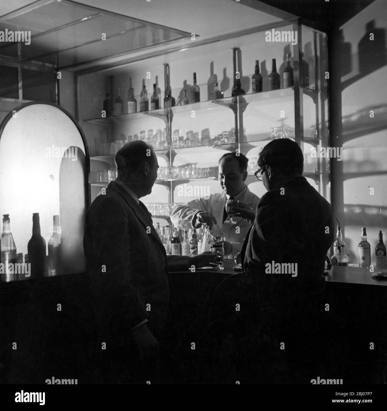 Le bar américain de l'hôtel Savoy, Londres, Angleterre - un bar réservé aux hommes servi par le barbier Johnny Johnson - années 1950 Banque D'Images