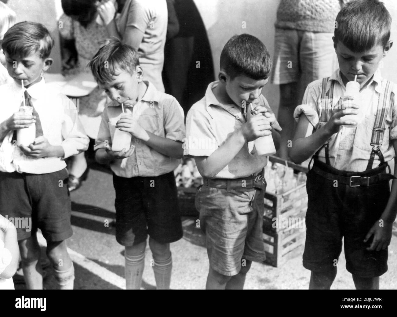 Les enfants boivent des bouteilles de lait à travers les pailles en vacances à Crayford, Kent, Angleterre - 1939 Banque D'Images