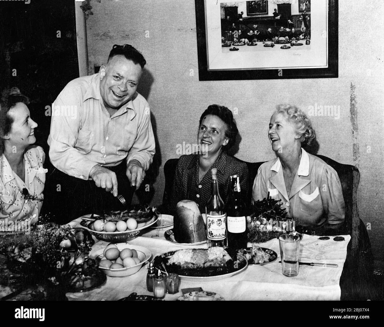 Lorsque M. Fred Davies, un directeur de la restauration du Canada, a effectué une visite dans son pays natal, l'Angleterre, après 40 ans d'absence, il n'est pas venu à mains vides. De retour dans sa ville natale, Dartford, pour rester avec sa sœur Mme Hutchins, sa collection de bonnes choses à manger et à boire comprenait un côté de bacon une yard et demi-long, 67 œufs frais et une bouteille de whisky écossais. Les amis et les voisins ont prêté une main prête à se débarrasser de cette prime hors-la-ration, mais il reste encore assez à laisser pour un parti de réunion avant que M. Davies ne retourne au Canada. - Photos: Tableau de fête M. Fred Davies sculpte le premier vent Banque D'Images