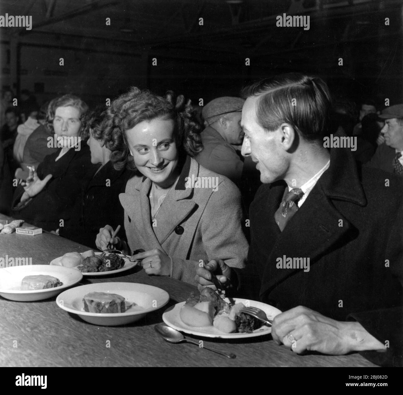 Sylvia Barker et Roland Jackson mangeant à la cantine de l'usine automobile pour laquelle ils travaillent. Ils paient un shilling par repas et depuis leur première réunion dans la cantine ils sont maintenant engagés à être mariés. - Birmingham, Angleterre - 9 juin 1949 - Banque D'Images