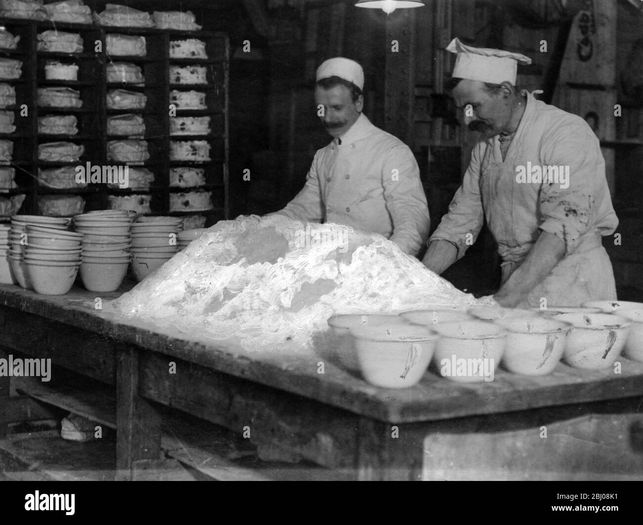 Boulangers au travail pétrissant la pâte pour faire du pain Banque D'Images