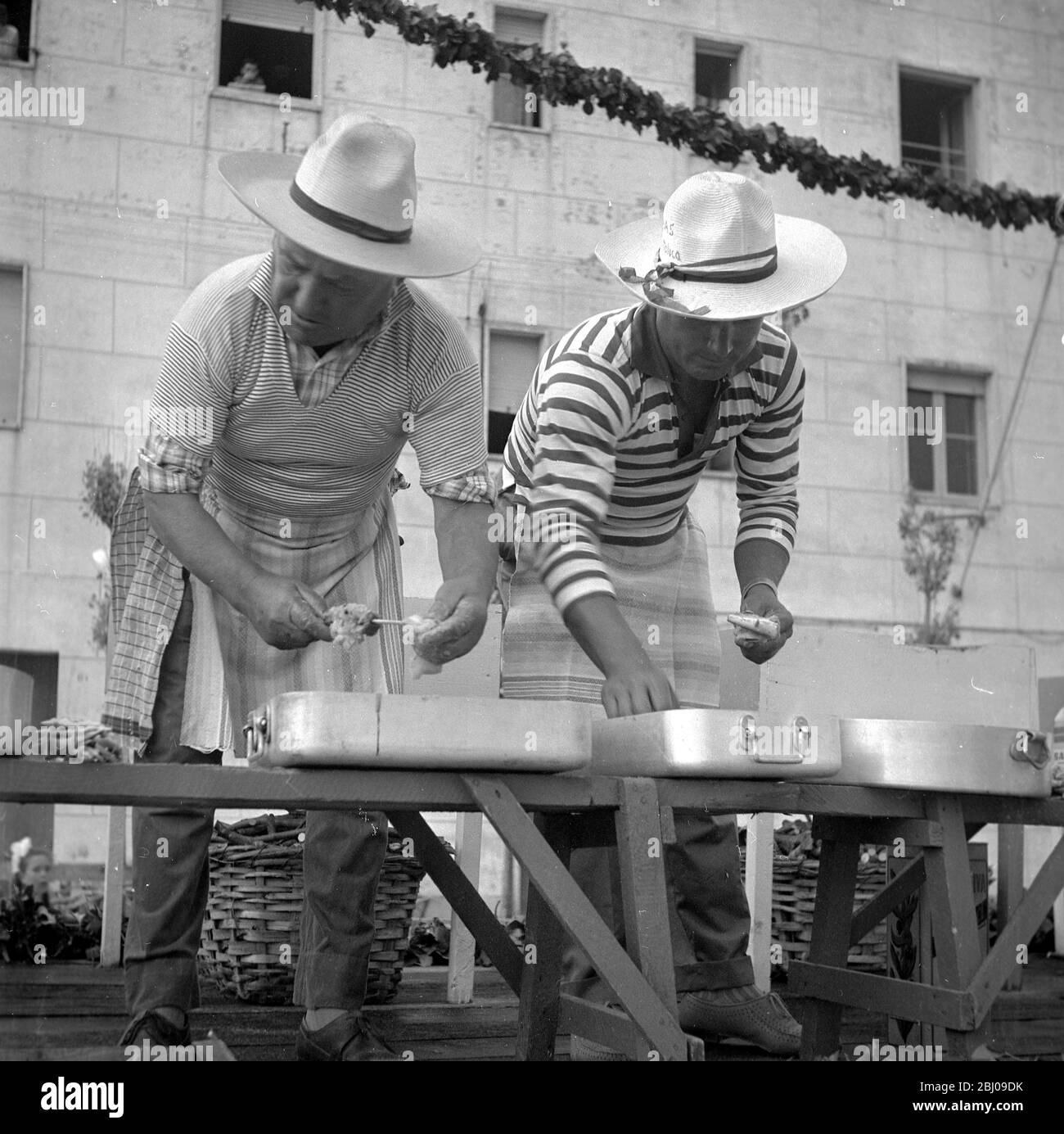 Cattolica , Italie . - les pêcheurs disent merci à la mer avec un Jamboree de poisson grillé et il y a des siècles ce jamboree a été dédié à la Sainte mère de l'épave bateau de pêche cuit poisson est offert gratuitement à quiconque le veut avec le vin local . - pêcheurs brochettes de maquereau prêtes à rôtir sur les feux de bois . - juillet 1959 Banque D'Images