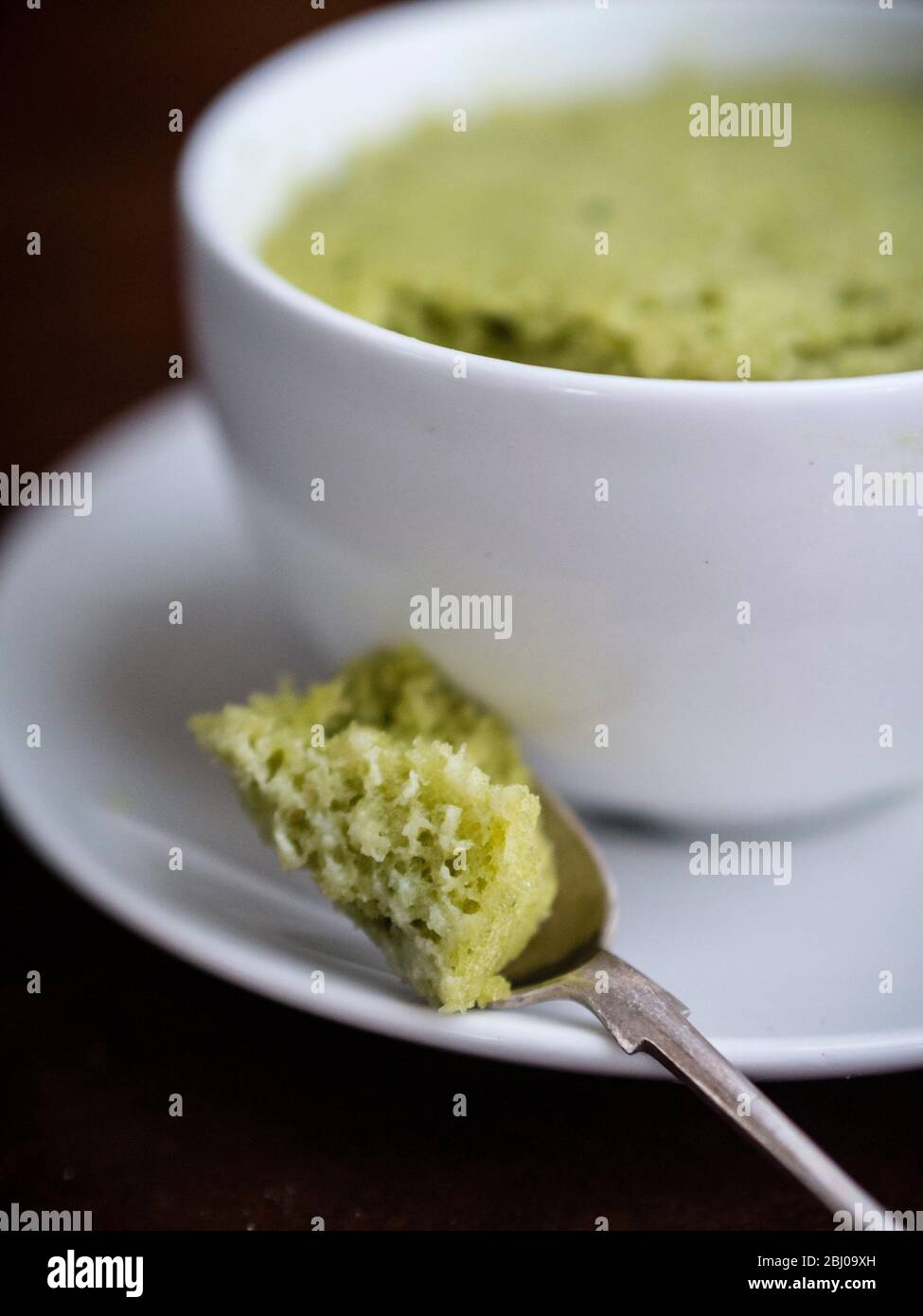 Délicieux gâteau simple composé d'amandes moulues et de thé vert matcha, cuit dans une tasse dans un four à micro-ondes. Banque D'Images
