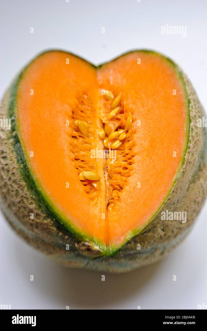 Face coupée de melon de cantaloup montrant chair et graines à l'intérieur - Banque D'Images