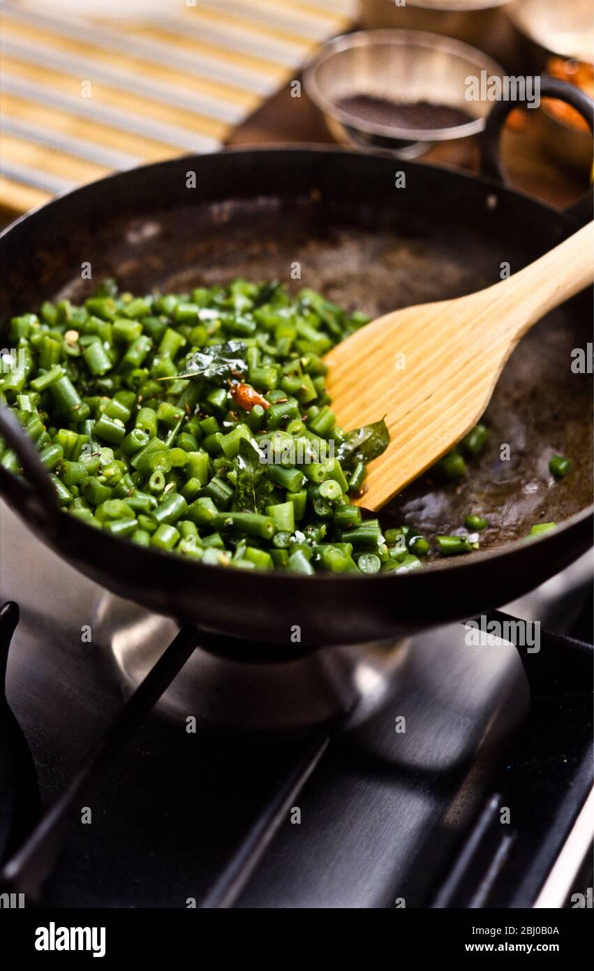 Haricots verts de style gujerati, blanchis et agités avec des graines de moutarde, du piment, de l'ail écrasé, des feuilles de citron vert et de l'assaisonnement - Banque D'Images
