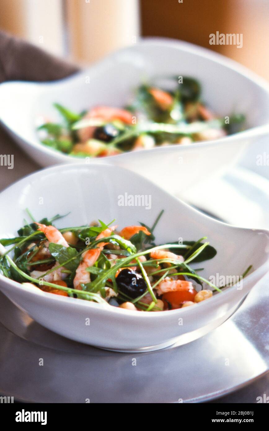 Salade de crevettes et de roquettes dans deux bols blancs modernes - Banque D'Images
