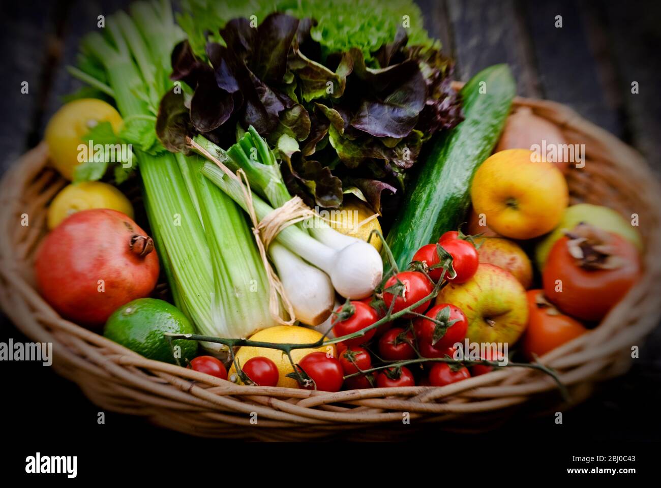 Panier de fruits et légumes frais sur la surface rouge - Banque D'Images