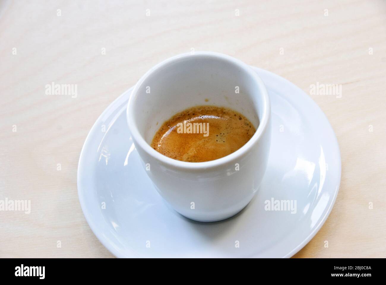Tasse en porcelaine blanche de café espresso fraîchement préparé raquette « crème » - Banque D'Images