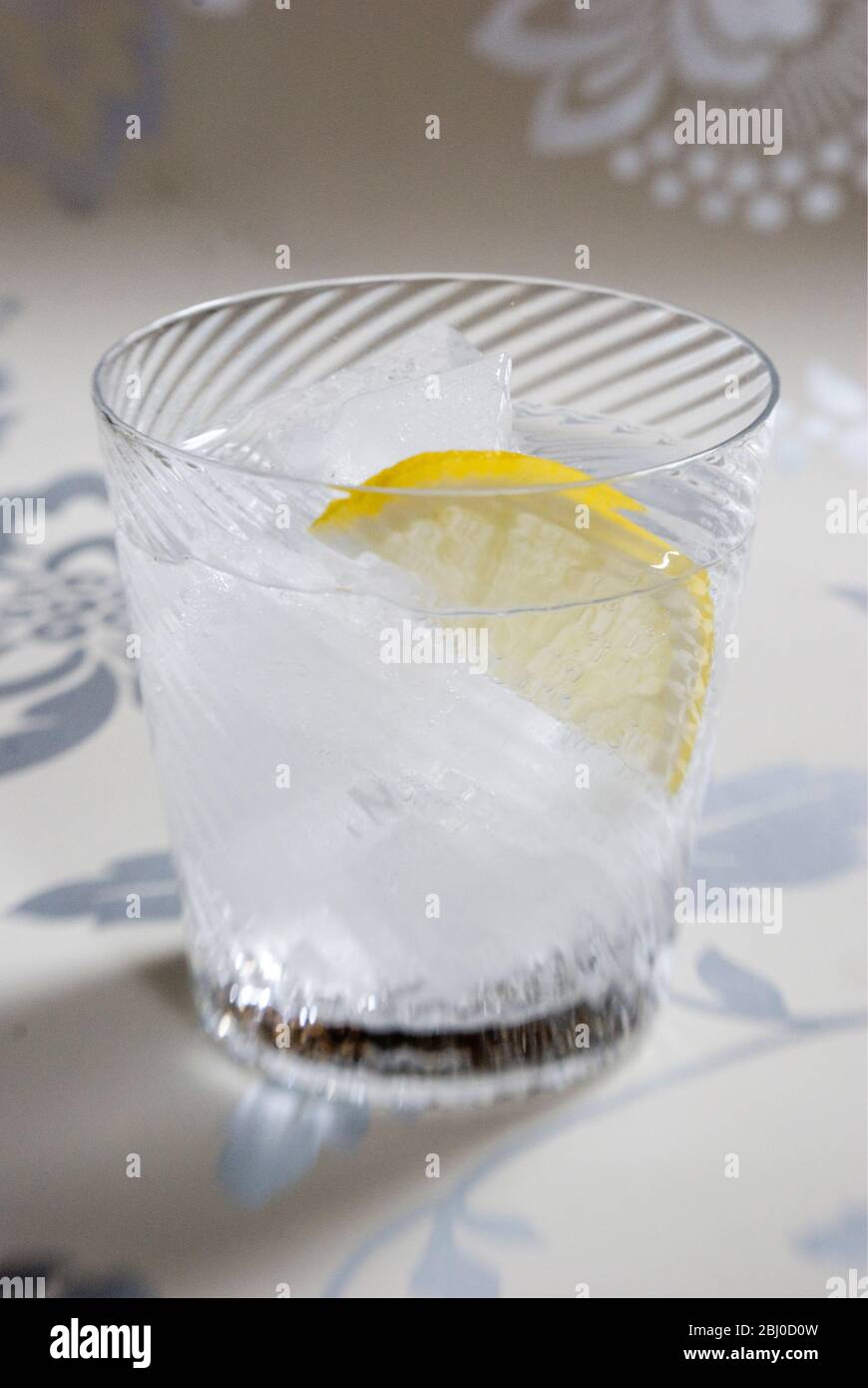 Verre soufflé fin en spirale de l'esprit clair avec soda ou tonique, et tranche de citron sur fond décoratif - Banque D'Images