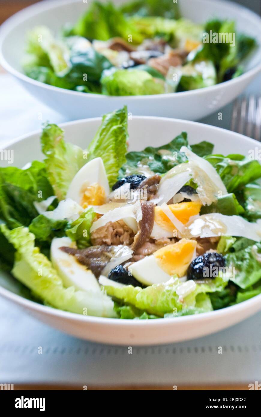 Bol blanc de la salade classique Nicoise, avec vinaigrette - Banque D'Images